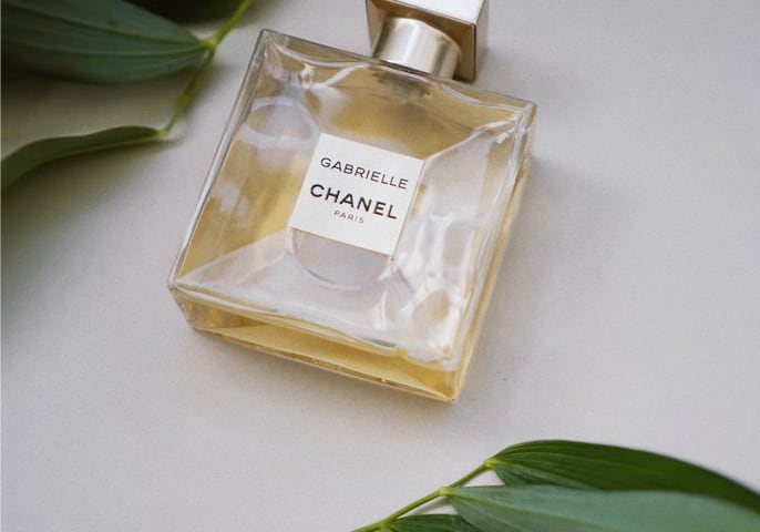 Picture of a perfume with green leaves.